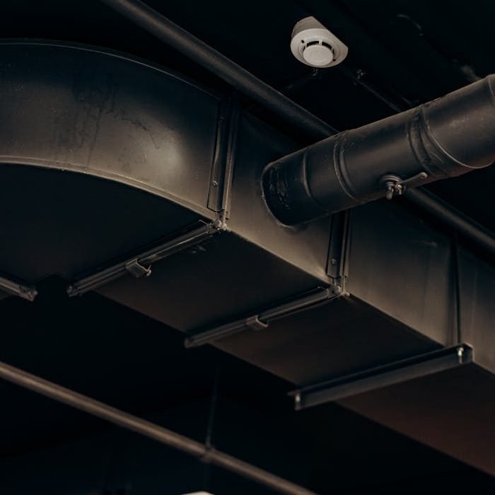 an-air-duct-of-a-building-8297856 Detailed view of industrial air ducts on a ceiling, showcasing modern urban design.
