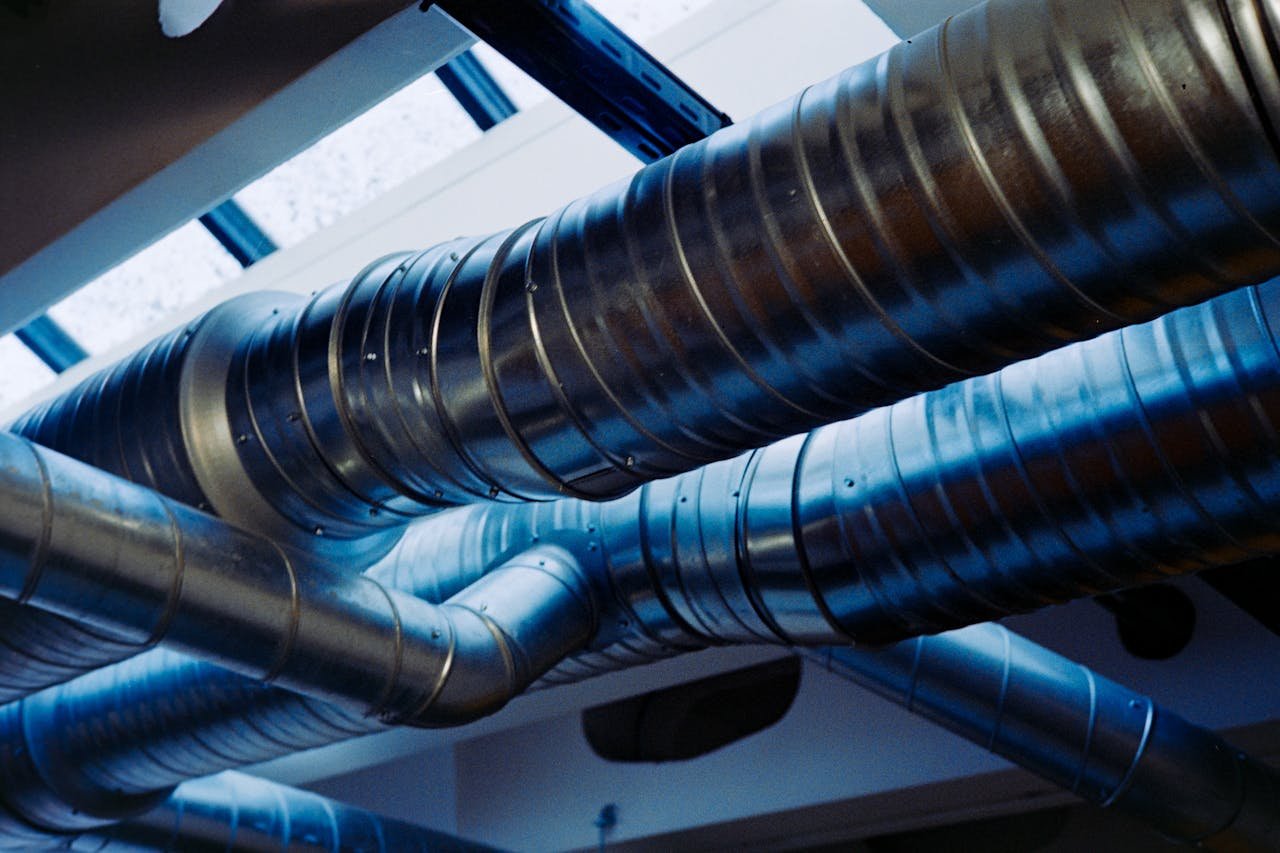 services-01 Close-up of a modern metallic ventilation system in an industrial setting.